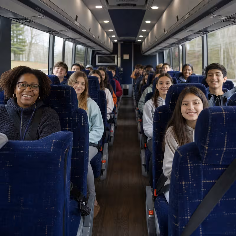 Group boarding a white charter bus for School Transportation transportation in Boca Raton